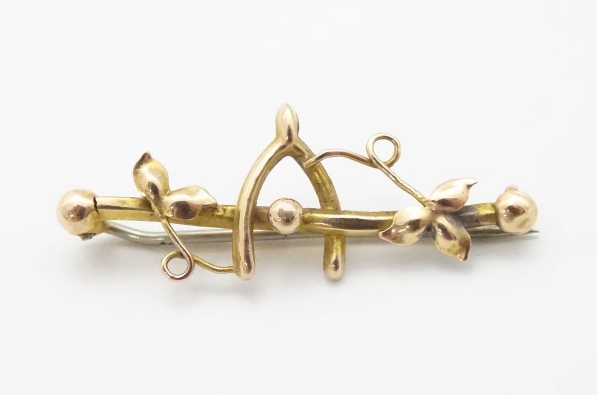 A 9ct gold brooch with wishbone decoration 1 1/4" wide CONDITION: Please Note -