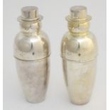 A pair of 21stC novelty silver plated cocktail shakers formed as snowmen, each 10 1/4" tall.