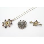 A star burst brooch set with paste stones marked 900 to reverse.