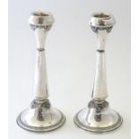 A pair of silver candlesticks with turquoise coloured cabochon decoration.