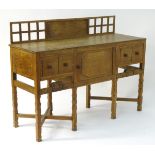 An early 20thC Arts & Crafts oak Cotswold school sideboard with a latticework upstand above a