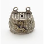 A charm / pendant formed as a miniature fishing creel with heraldic symbols to one side.