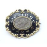 A 19thC gold mourning brooch with plaited lock of hair to centre ,