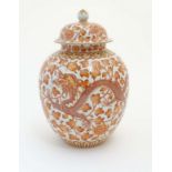 A Chinese orange and white lidded ginger jar decorated with dragons,
