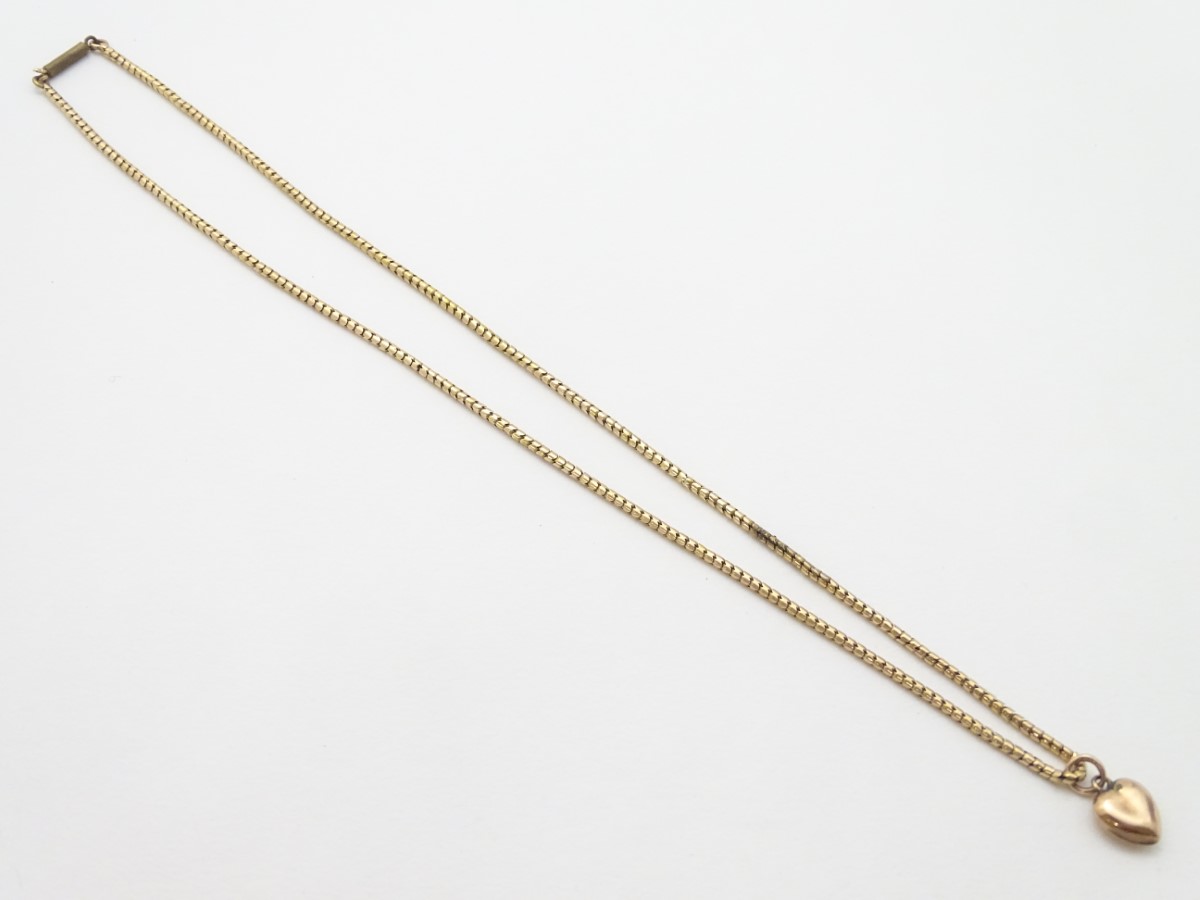 A gold chain (tests as 14ct) with a 9ct gold heart shaped charm / pendant. - Image 10 of 10