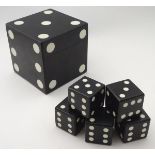 An ornamental cubic box in the form of dice, in black finish with white markers.