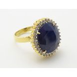 A 14ct gold ring set with large oval sapphire bordered by diamonds. The setting approx.