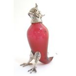 A 21stC novelty claret jug / decanter formed as a parrot with red glass body and silver plate
