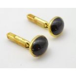 A pair of 9ct gold cufflinks set with garnet cabochon.