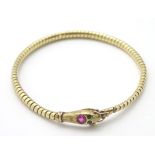 An 18ct gold bracelet formed as a snake / serpent set with ruby spinel to head and green paste eyes.