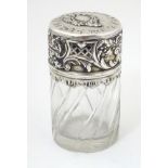 A cut glass jar / scent / perfume bottle with Continental silver mounts and lid with floral and
