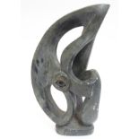 A large abstract soapstone sculpture with central eye motif, possibly a stylised eagle,