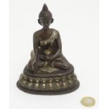 A cast bronze Nepalese Buddha sat cross legged on a Lotus Petal base, touching earth.