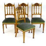 A set of four early 20thC Art Nouveau dining chairs with carved cresting rails and pierced central