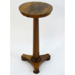 A mid 19thC rosewood lamp / wine table with a circular top above a canted stem and triformed base