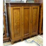 An early 20thC mahogany wardrobe with a moulded cornice above a dentil carved frieze and three