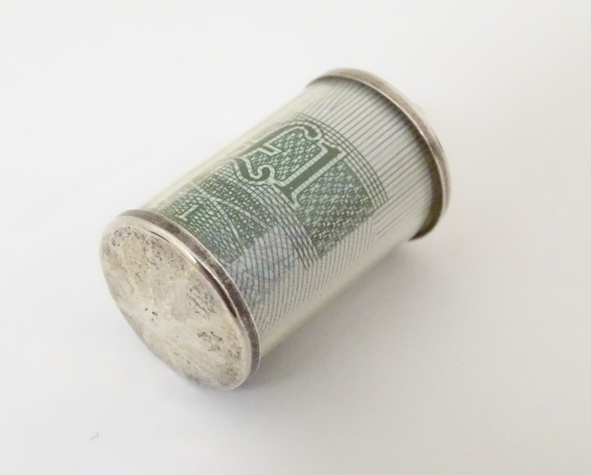 A novelty pendant charm of cylindrical form and containing a £1 note.