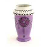 A Shelley vase with a purple ground, decorated with Art Nouveau flowers and pinwheels.