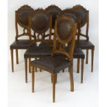 A set of six oak Louis XVI style dining chairs with carved cresting rails and embossed leather back