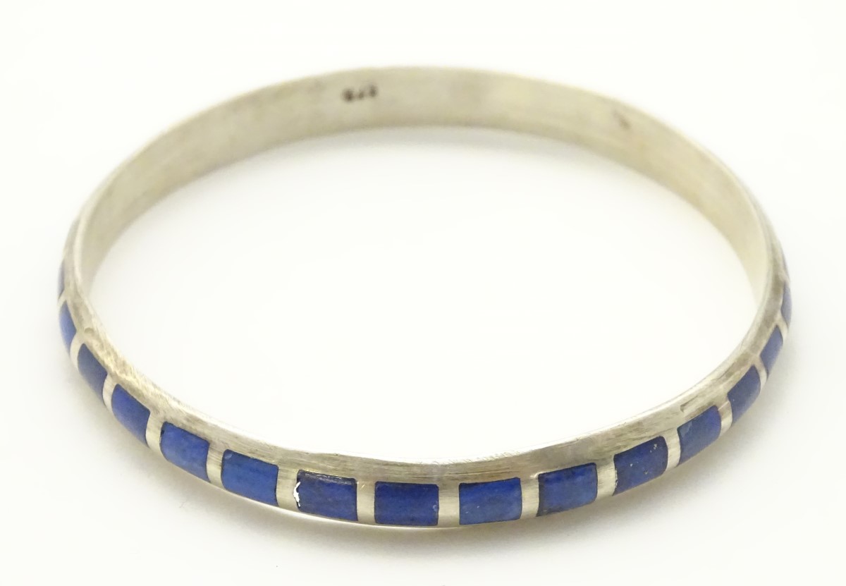 A silver bangle bracelet set with lapiz lazuli CONDITION: Please Note - we do not