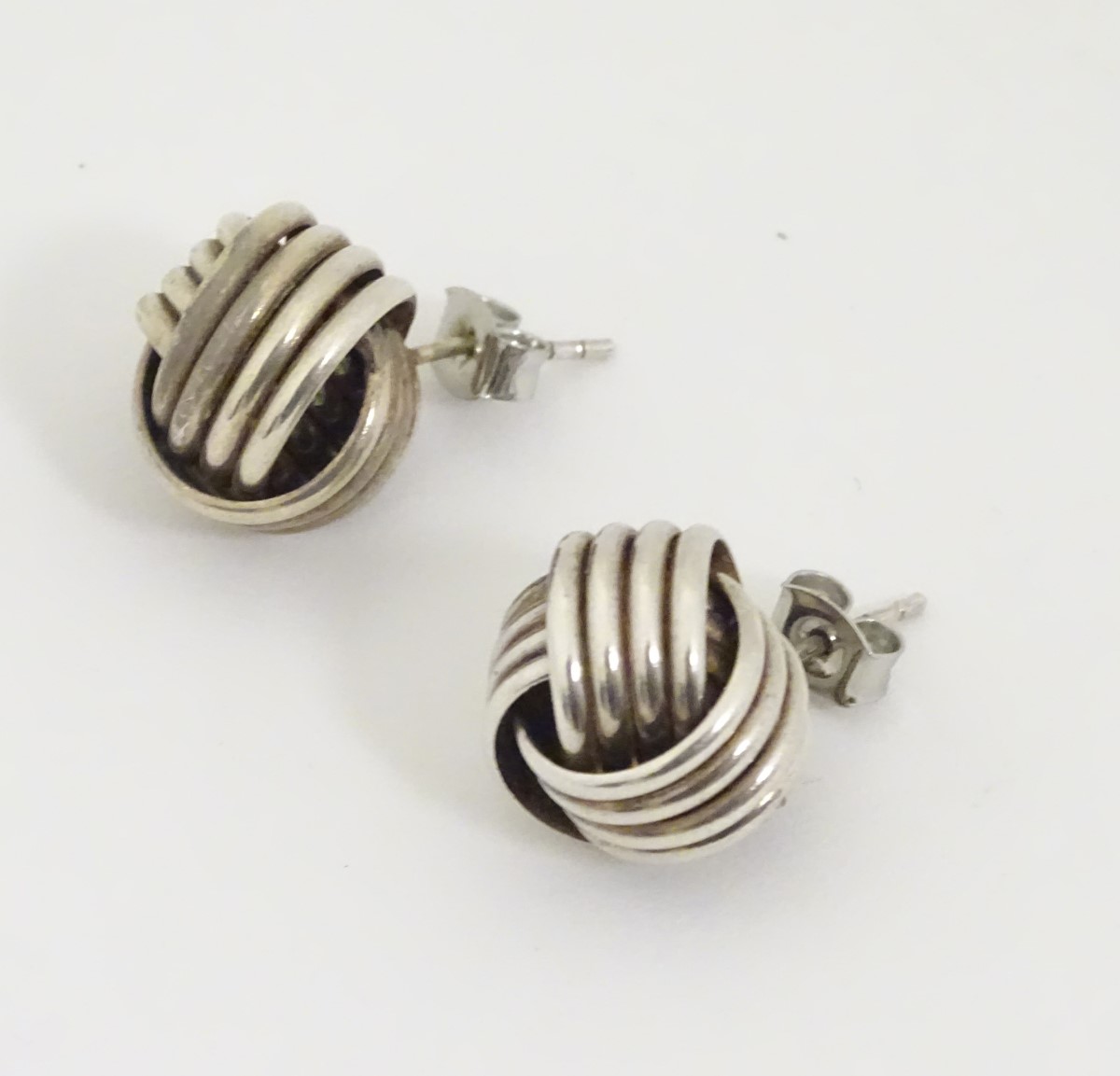 A pair of white metal stud earrings formed as large knots. - Image 3 of 4