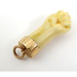 A carved pendant formed as a figa hand / clenched fist with gold mount.