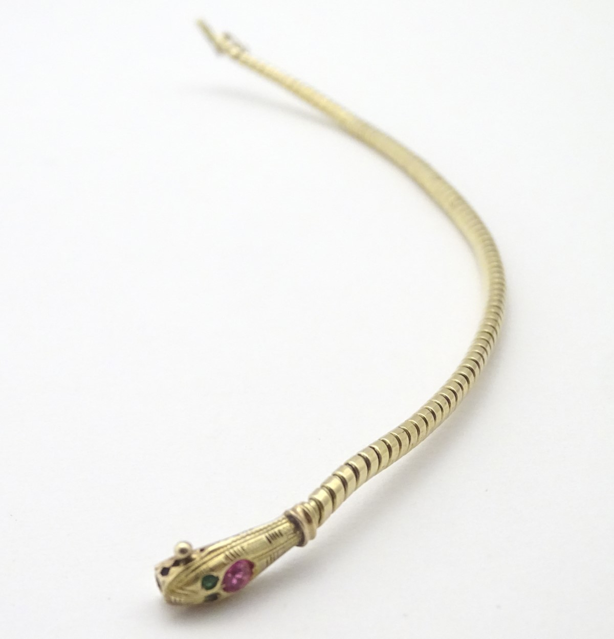 An 18ct gold bracelet formed as a snake / serpent set with ruby spinel to head and green paste eyes. - Image 4 of 4