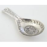 A Geo III silver caddy spoon with engraved decoration and filigree oval to bowl.