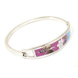 A Mexican silver bangle formed bracelet with butterfly and flower decoration and set with enamel