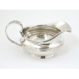 A silver jug / sauce boat with floral decoration to handle hallmarked London 1826 maker William