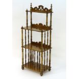 A 20thC burr walnut four tier whatnot with a shaped pierced upstand above four shelves with turned