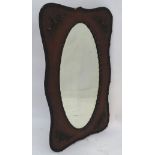 An early 20thC oak mirror with a carved surround, carved frame and bevel edged oval mirror.