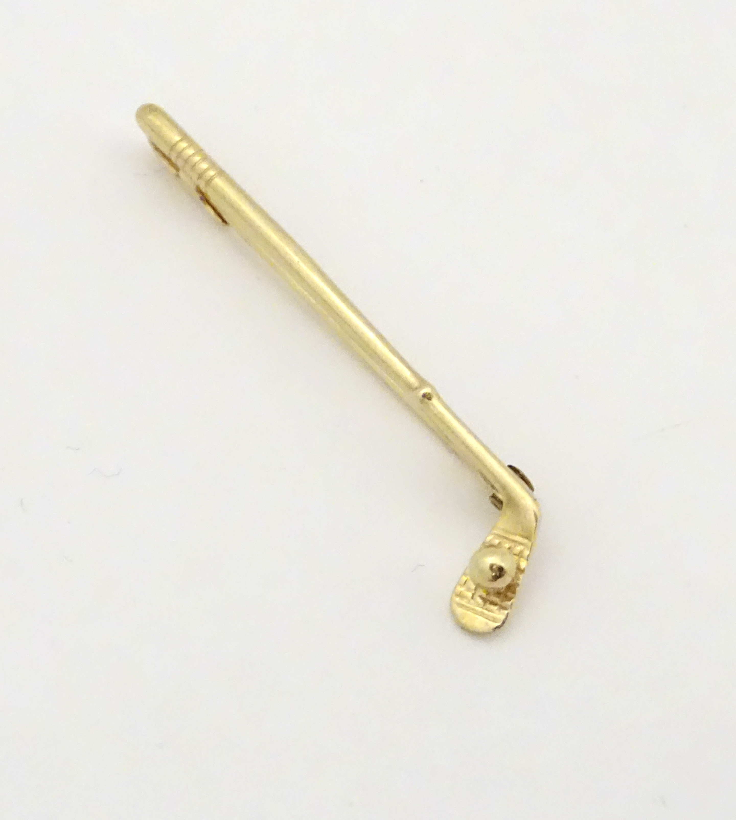 A 9ct gold brooch / pin formed as a golf club and ball.
