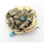 A late 19thC / early 20thC yellow metal brooch with floral and turquoise detail.