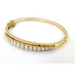A 9ct gold bangle bracelet set with graduated seed pearls CONDITION: Please Note -