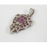 A silver pendant set with a profusion of rubies,