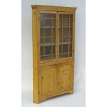 A 19thC large pine corner cupboard with a moulded cornice above two astragal glazed doors and two