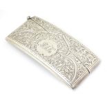 A silver card case of shaped form with engraved decoration.
