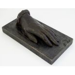 A folk art carved wooden model of a left hand on a rectangular base. Approx. 3 1/4" high.