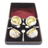 A cased set of 4 Victorian silver salts with floral and scroll decoration with gilded bowls and