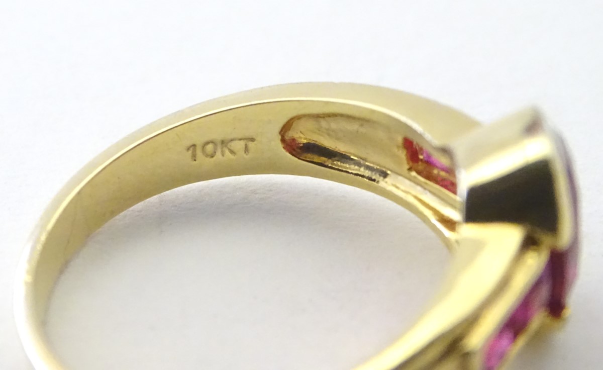 A 10ct gold ring set with central ruby flanked by 2 further rubies to each shoulder. - Image 5 of 5