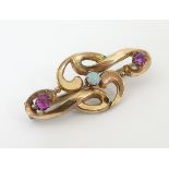 An Art nouveau gold brooch set with amethysts and central opal.
