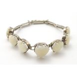 A vintage silver bracelet set with 7 graduated heart shaped opal cabochon CONDITION: