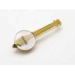 A 9ct gold brooch formed as a banjo / Ukulele with mother of pearl detail,