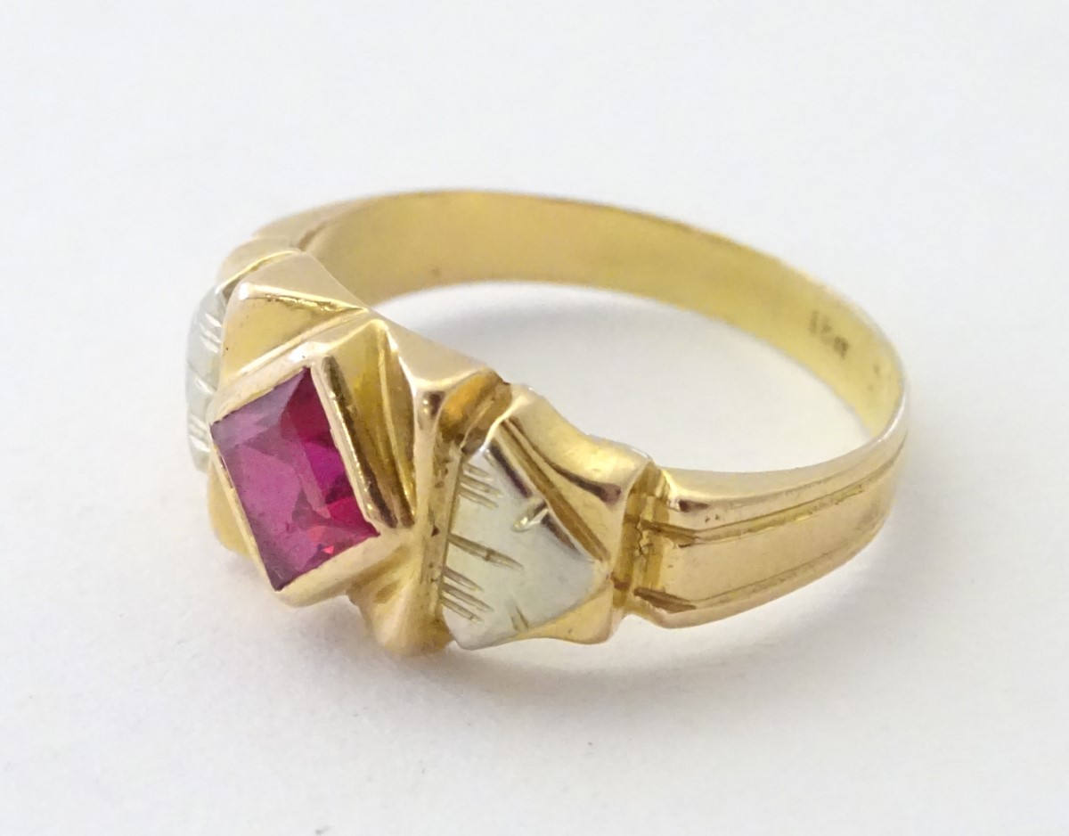 An 18ct gold ring set with central ruby in an Art Deco style setting.