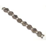 A silver bracelet with niello decorated oval and filigree links.