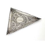 A Victorian silver pin dish of triangular form with embossed decoration.