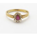 A 9ct gold ring set with pear cut spinel bordered by diamonds.