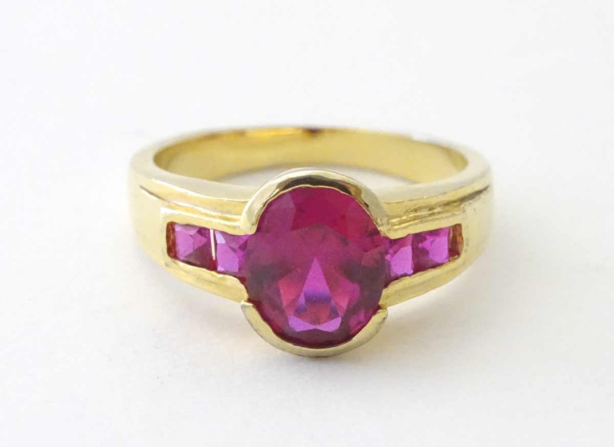 A 10ct gold ring set with central ruby flanked by 2 further rubies to each shoulder. - Image 2 of 5