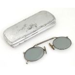 A cased pair of Edwardian pince nez spectacles / glasses with a nickel frame, telescopic bridge,